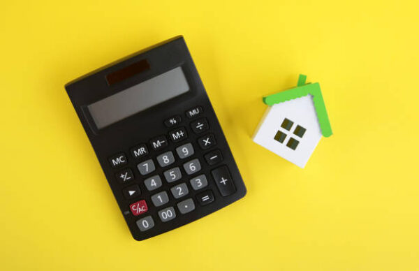 Miniature house and calculator, Home finance concept