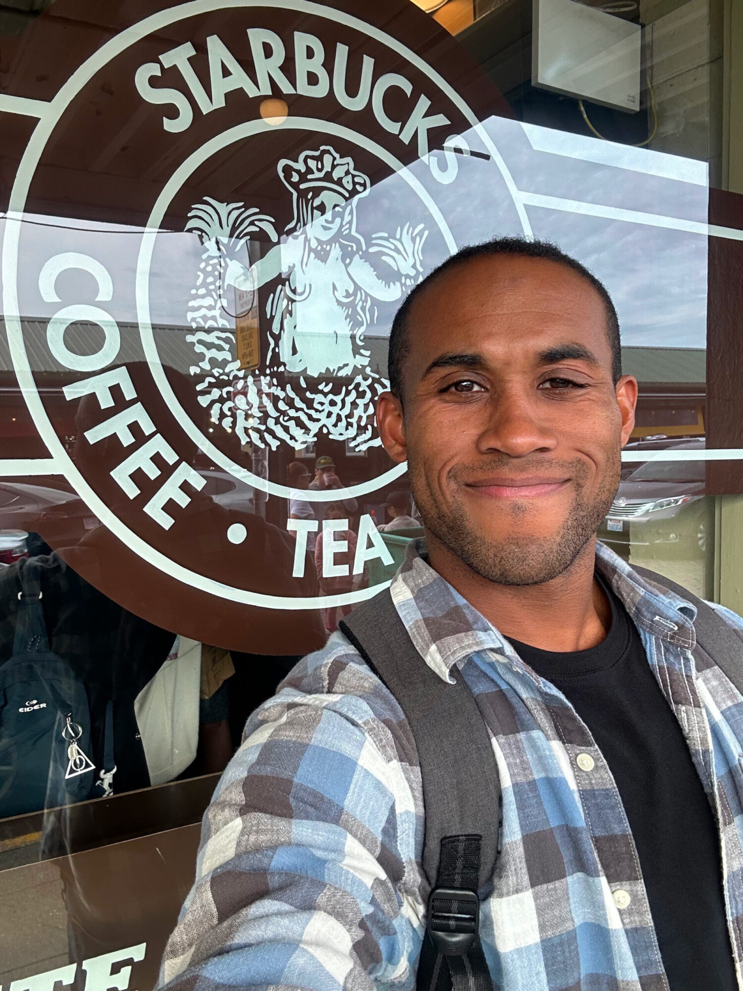 Financial fitness coach stands in front of a famous entrepreneurial coffee brand.